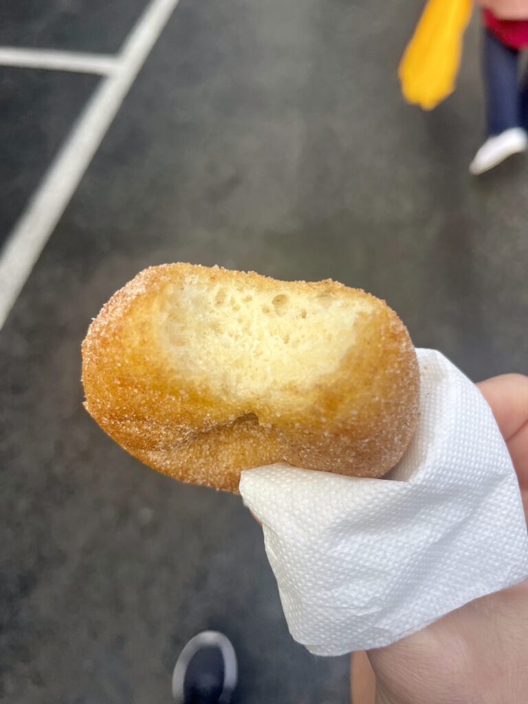 Looking down at a half-bitten cinnamon donut in a white tissue