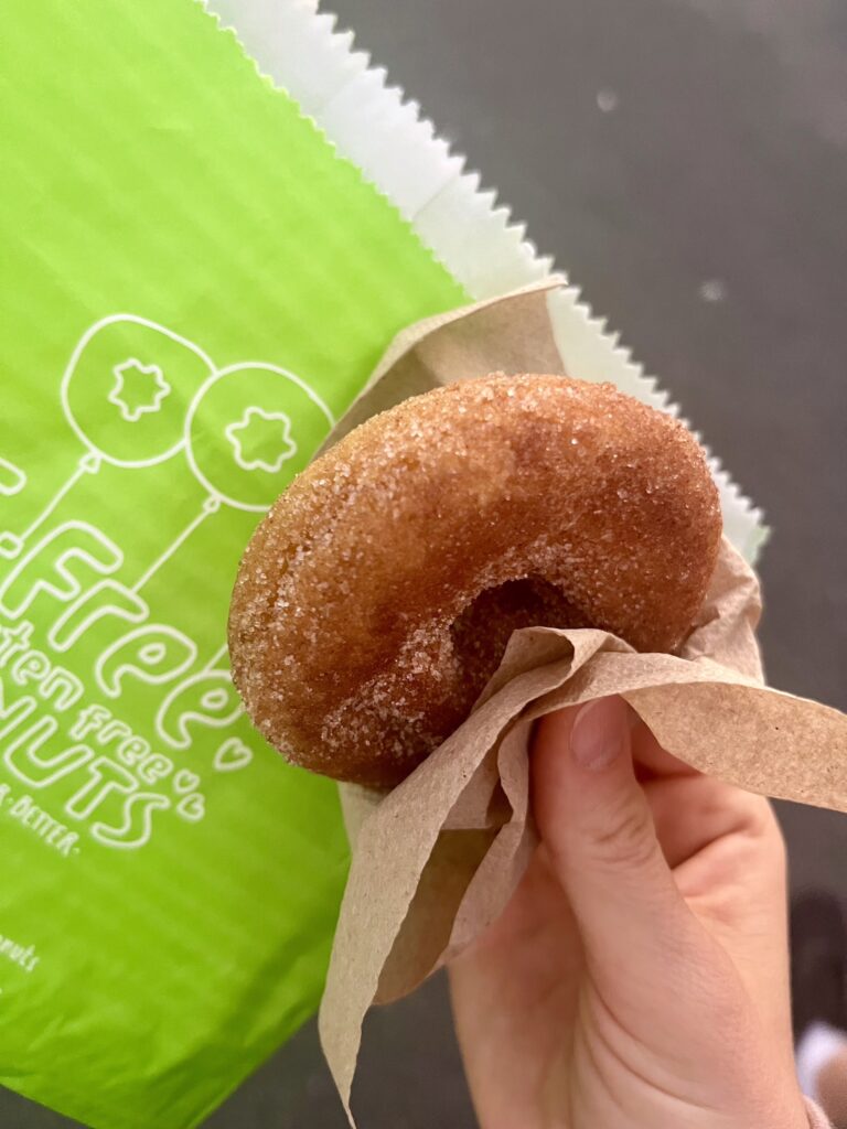 Looking down at a cinnamon donut in front of a green bag