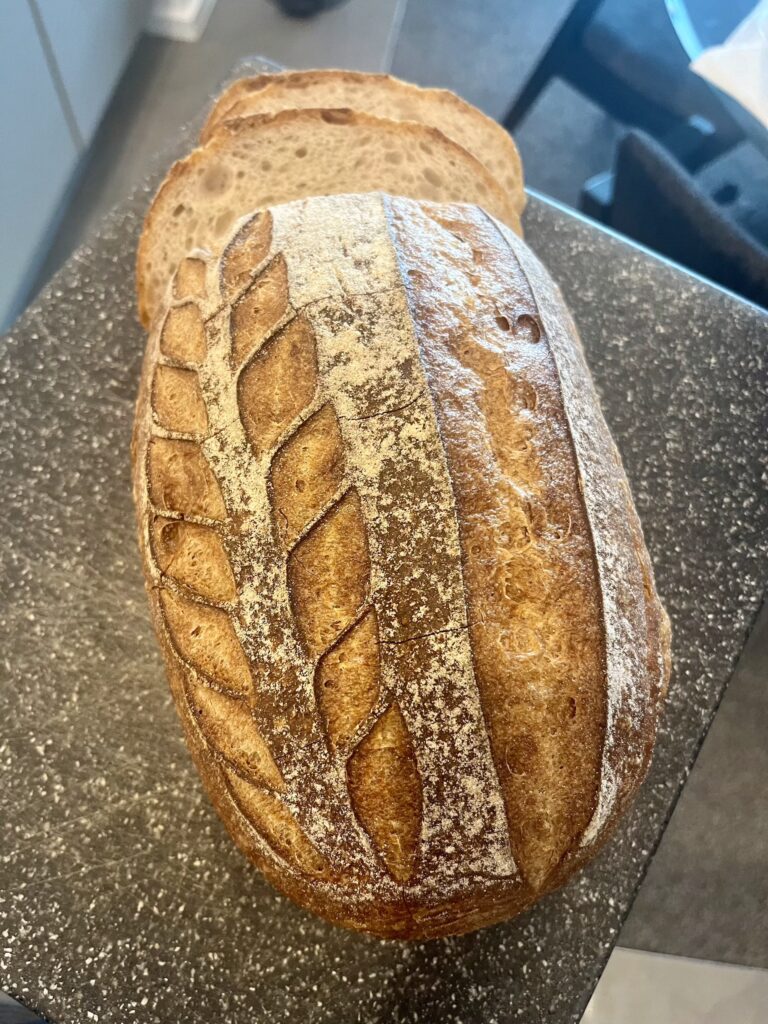 Looking down at a gluten-free sourdough bread on a speckled grey cutting board
