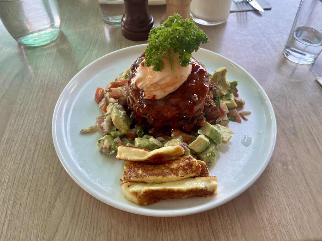 Looking down at corn fritters with avocado and halloumi around them