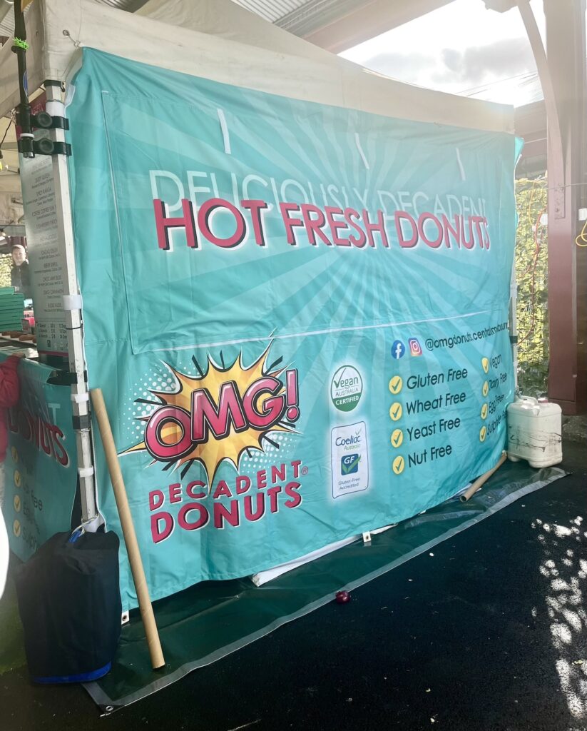 Looking at the side of a donut stall banner with varying word sizes and colours