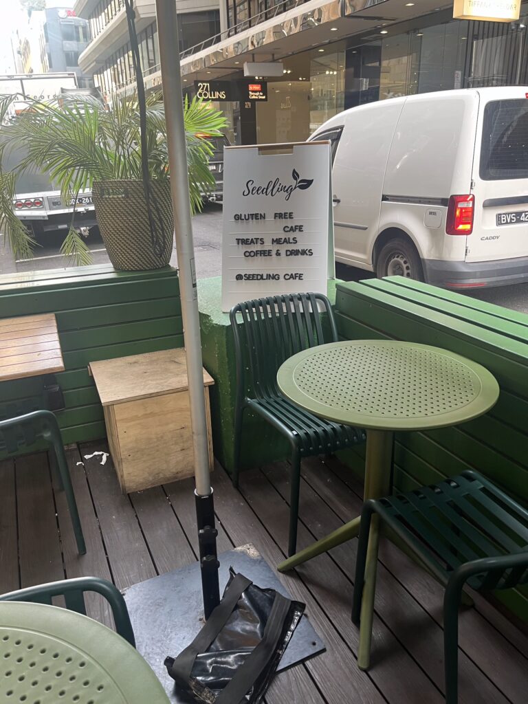 A green patio area outside a cafe with green chairs and tables